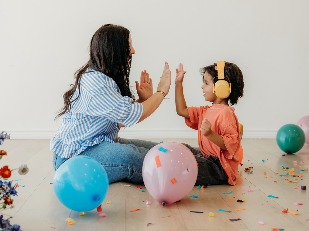 A woman and child sharing a high five while playing