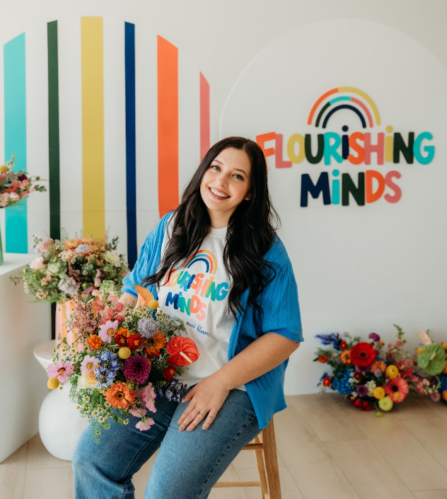 Flourishing Minds founder holding a colorful bouquet.