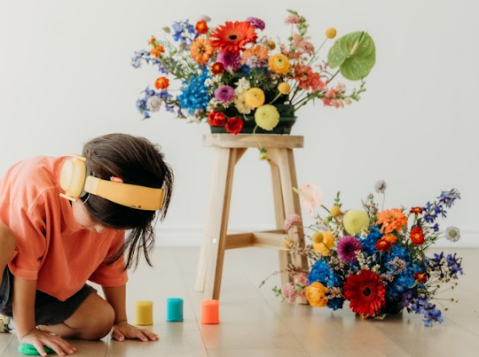 Colorful bouquet held in front of the Flourishing Minds studio backdrop